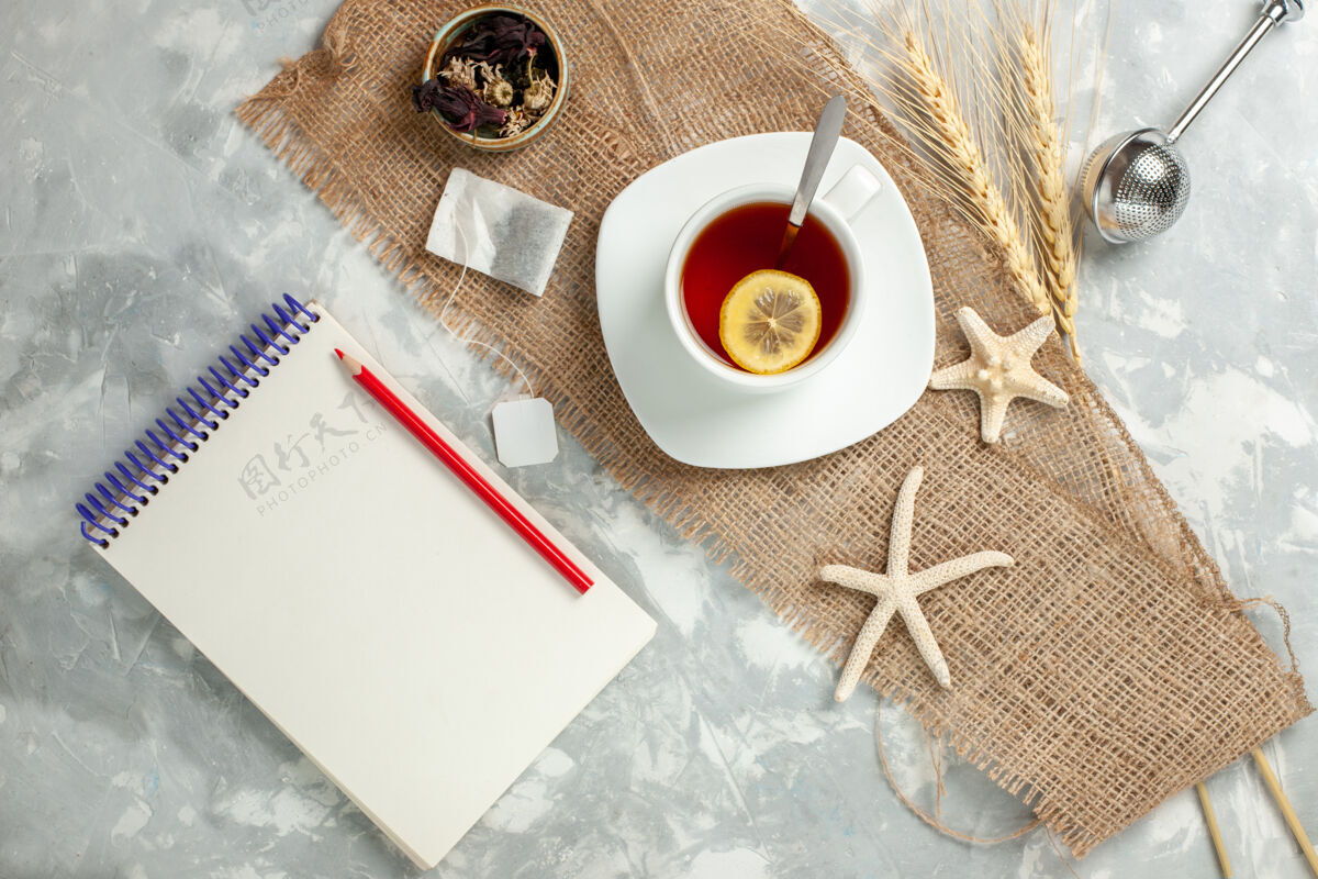 钢笔顶视图一杯白桌柠檬片茶喝水果柠檬笔记笔记本茶