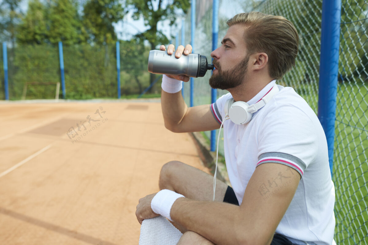 网球玩家在喝水水瓶球员休息