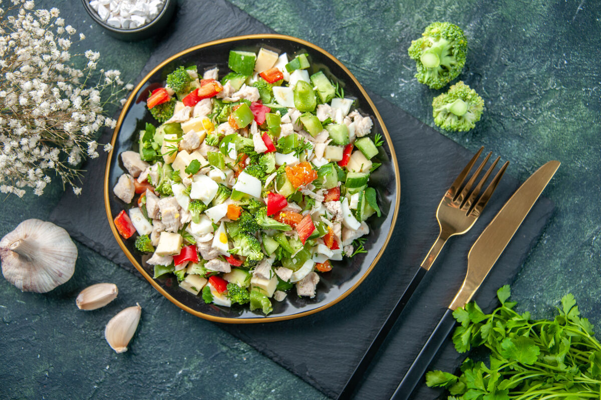 里面顶视图美味的蔬菜沙拉在盘子里用叉子在深蓝色的背景上餐厅用餐颜色健康饮食新鲜的菜肴午餐食物蔬菜沙拉叉子