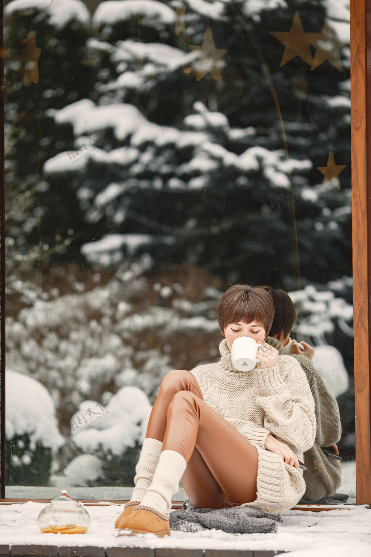 天气穿着白毛衣 喝茶的女人的特写肖像水壶雪茶