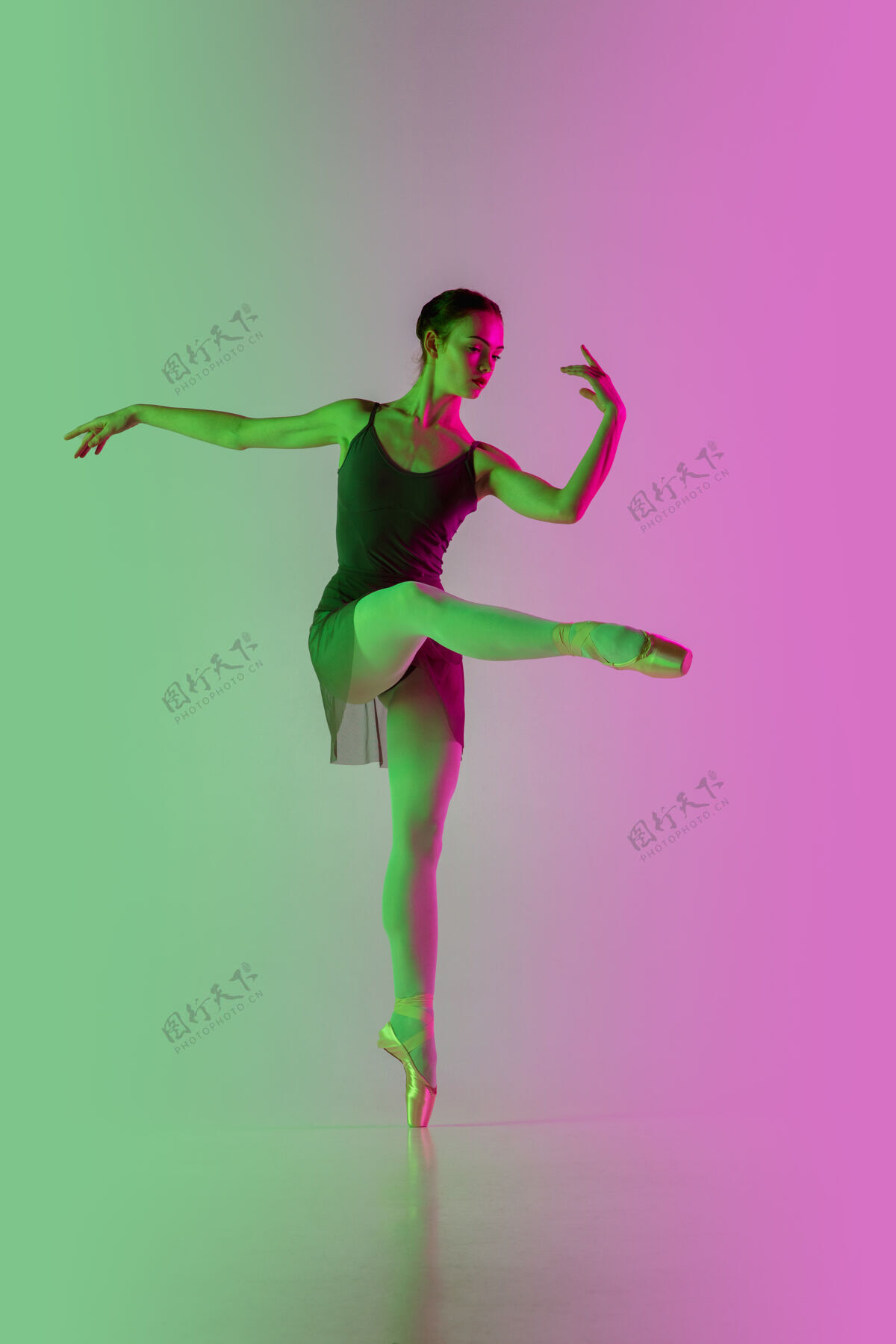 芭蕾轻年轻而优雅的芭蕾舞演员在霓虹灯下被隔离在渐变的粉绿色墙壁上艺术 动作 动作 灵活性 灵感概念灵活的芭蕾舞演员 失重跳跃女人动作优雅