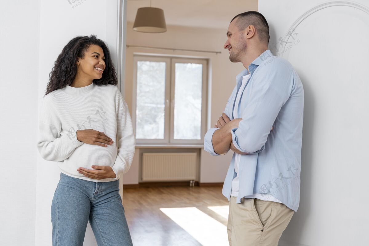男性笑脸怀孕夫妇站在新房子外面不动产土地所有权财产