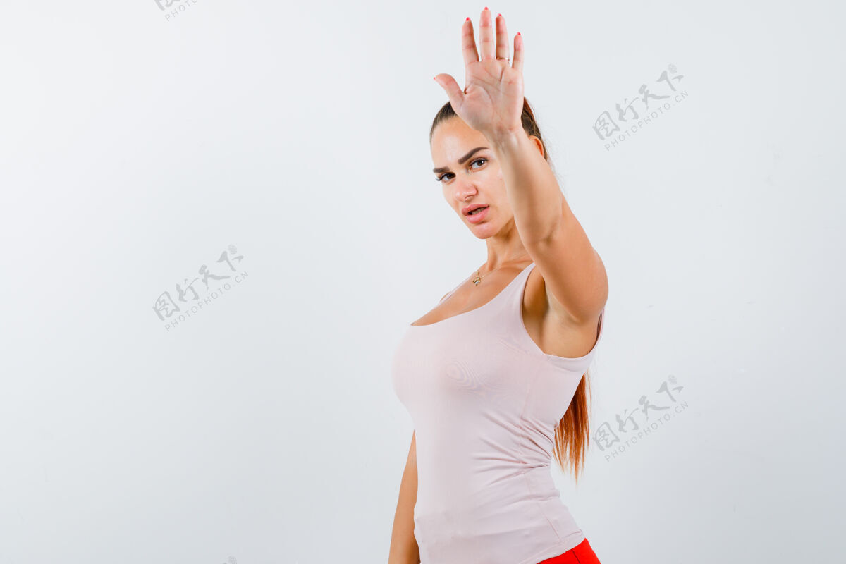 停止身穿白色背心的年轻女性 展示着停下来的姿势 看起来很自信 正面视图年轻清洁皮肤护理