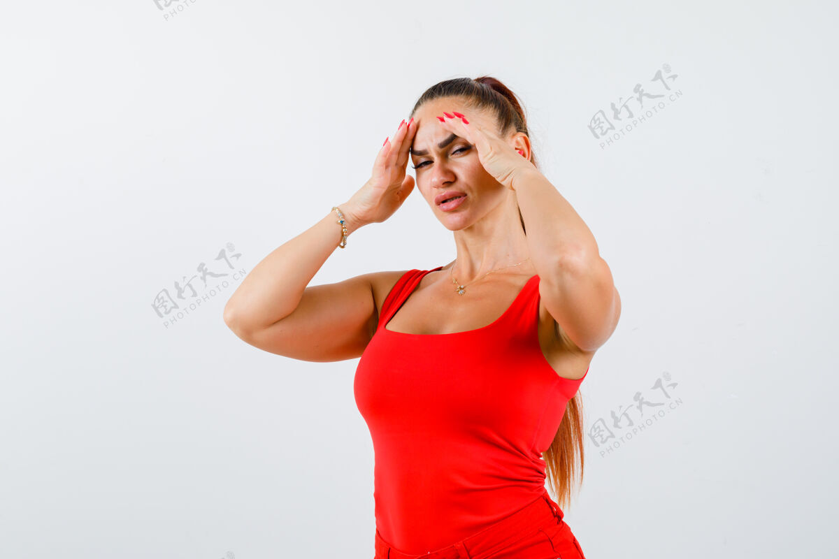 成人照片中的年轻女性手挽着手 头戴红色背心 穿着裤子 看上去筋疲力尽孤独痛苦年轻
