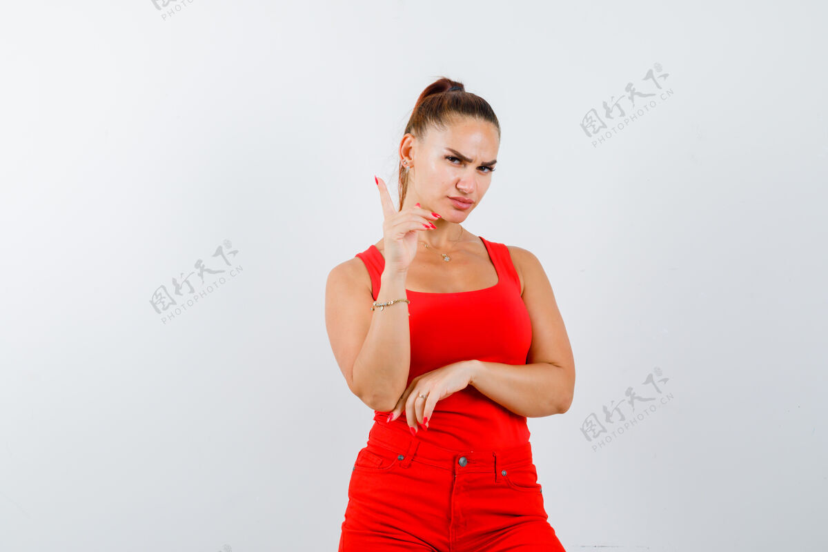 干净穿红色单品的年轻女士 红色裤子 正对着前方 表情严肃柔软前面严肃