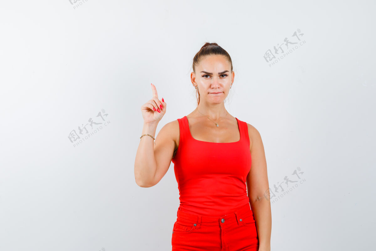 裤子年轻的女士指着红衬衫 红裤子 看起来很自信 正面视图健康娇惯健康