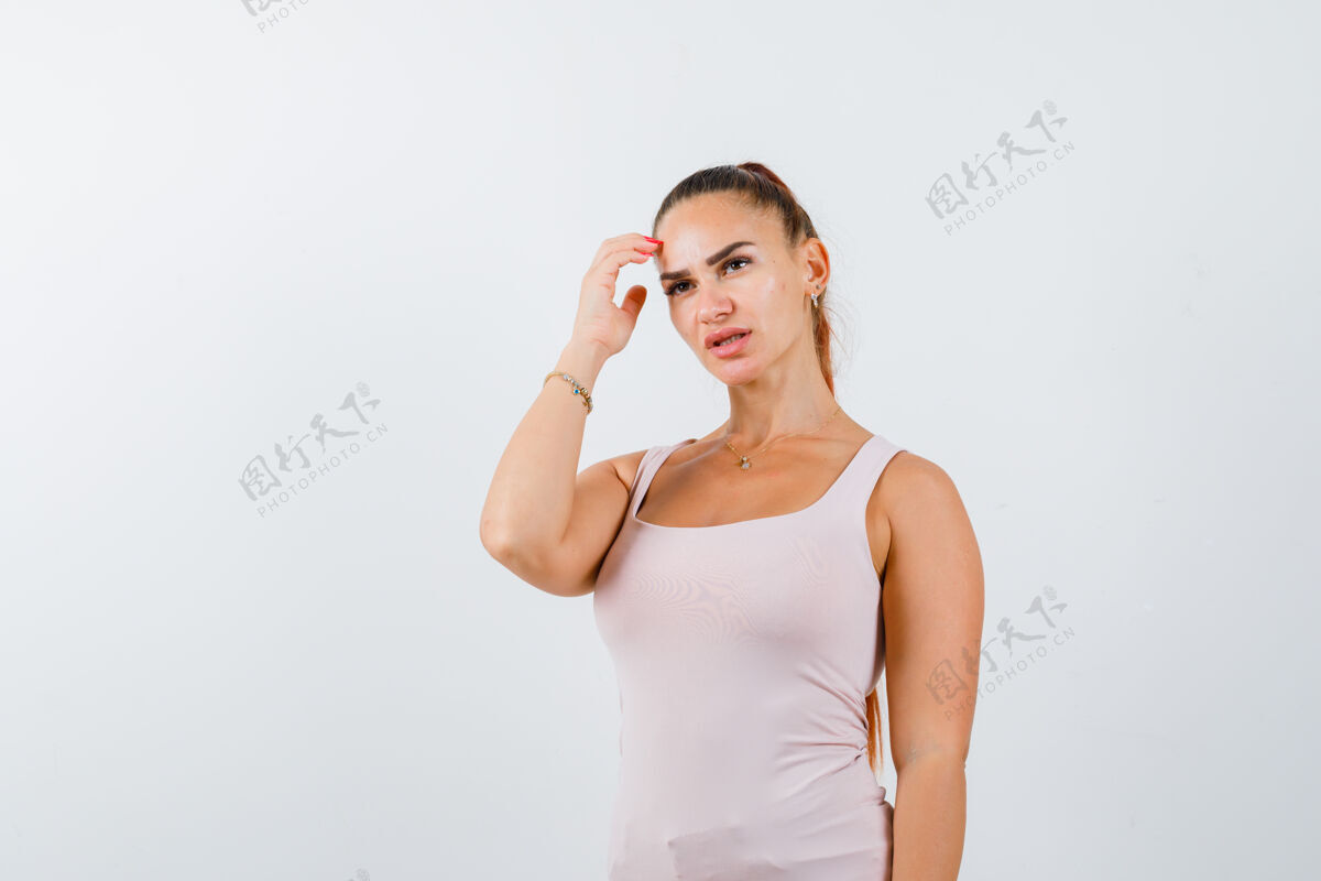 健康年轻女子在白色背心搔首弄姿 看着若有所思 前视图女性水疗前面