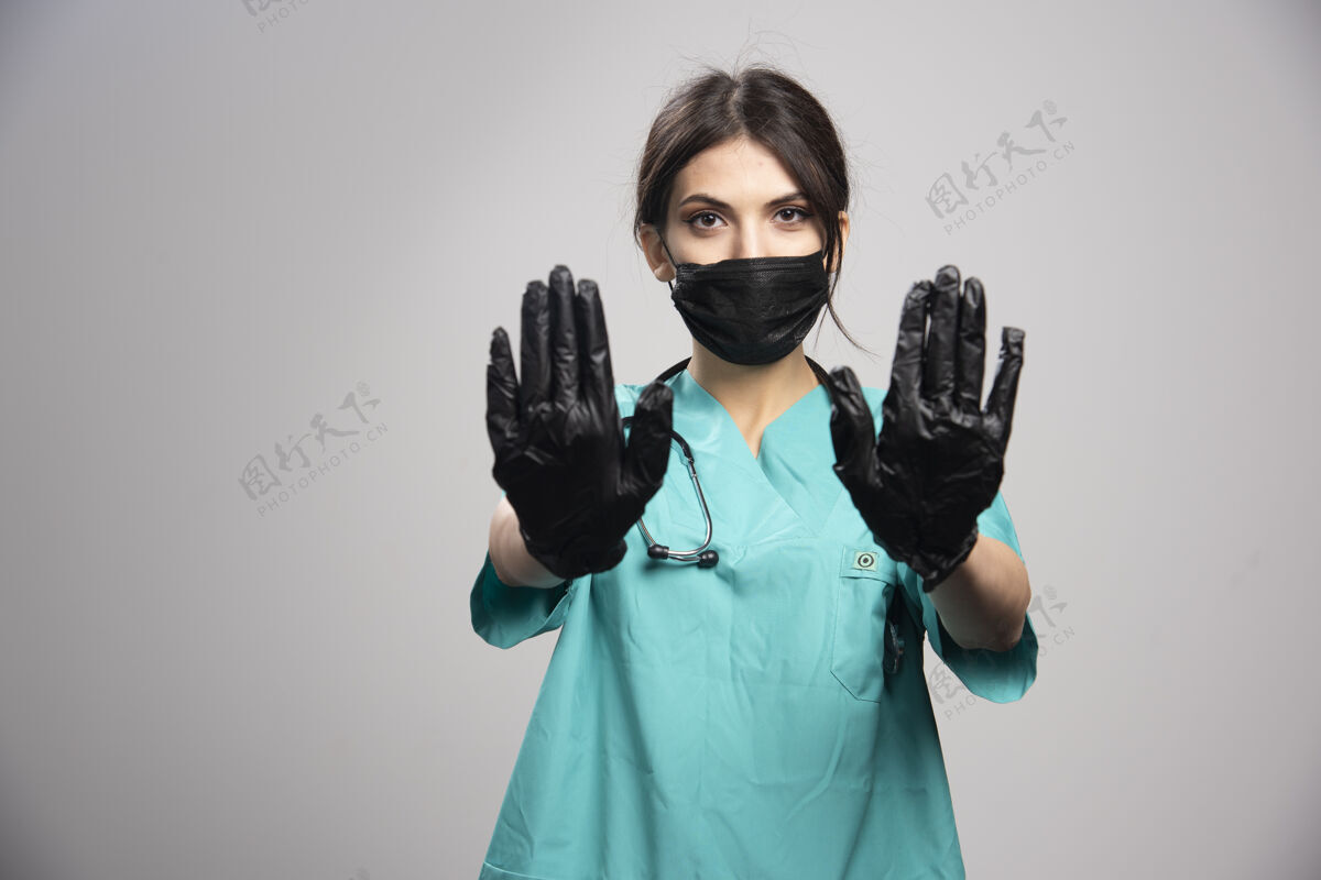 职业女医生戴着灰色的防护面具和手套个人工作治疗