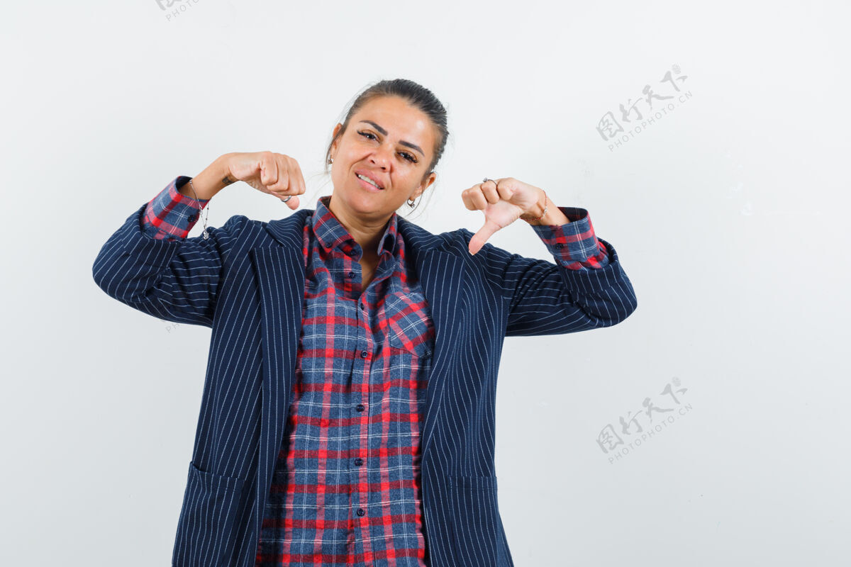 衬衫身穿衬衫 夹克衫的金发女郎用大拇指指着自己 看上去很自豪 正对着前方脸微笑成人