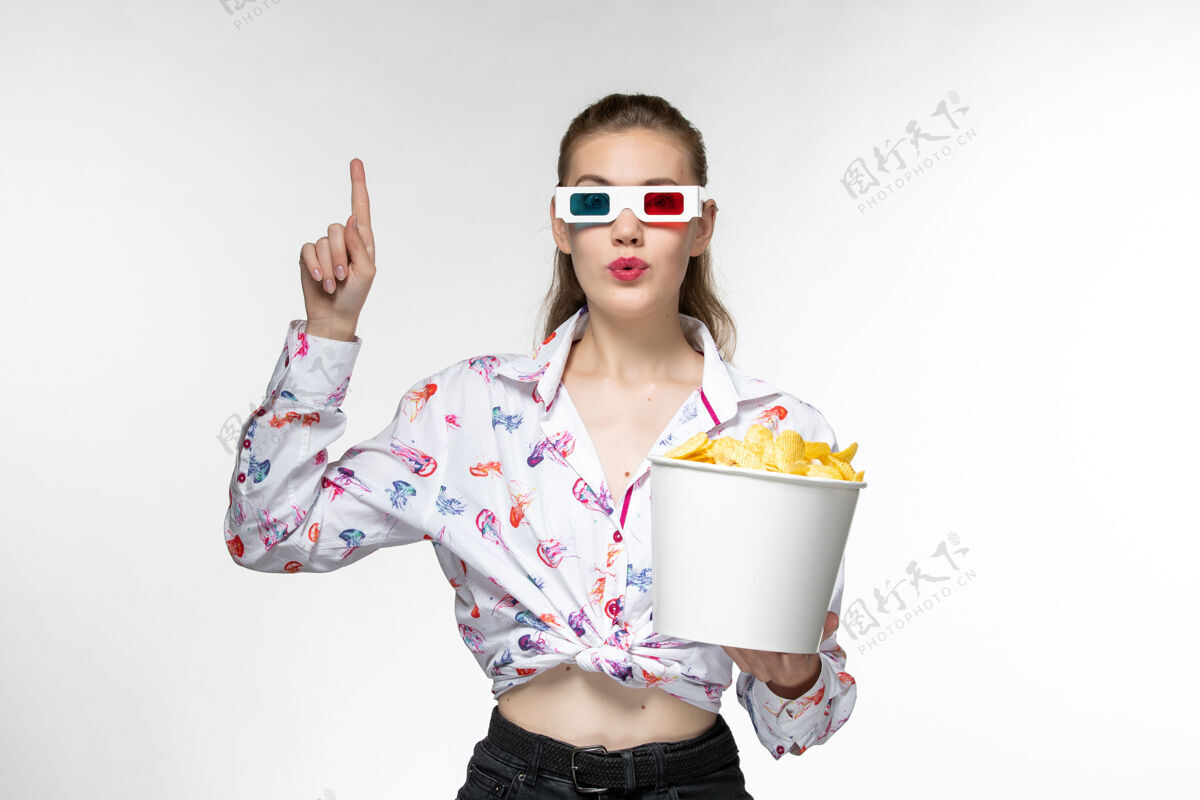 年轻女性正面图：年轻的女性手提篮里放着薯片 戴着d型太阳镜 浅白色的表面太阳镜篮子土豆
