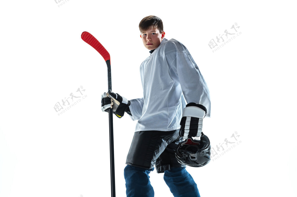 活跃严肃的年轻的冰球运动员 冰球场上的棍子和白色背景运动员穿着装备和头盔练习运动的概念 健康的生活方式 运动 运动 动作强壮棍棒人