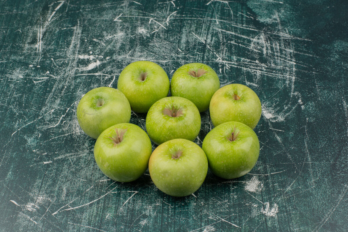 苹果大理石表面有三个青苹果成熟顶视图多汁