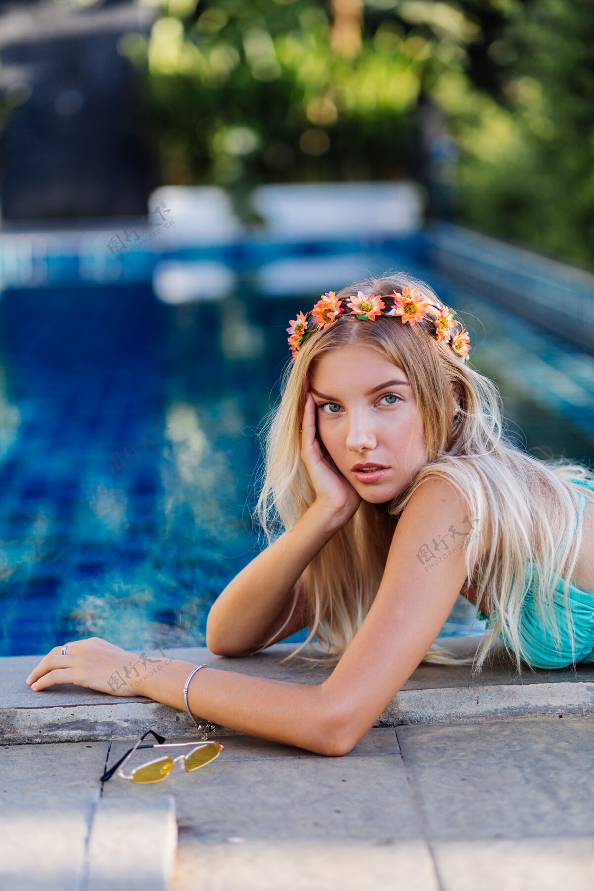 玫瑰身着蓝色比基尼 头戴花环的年轻快乐金发女人的肖像花环泳池边岛屿