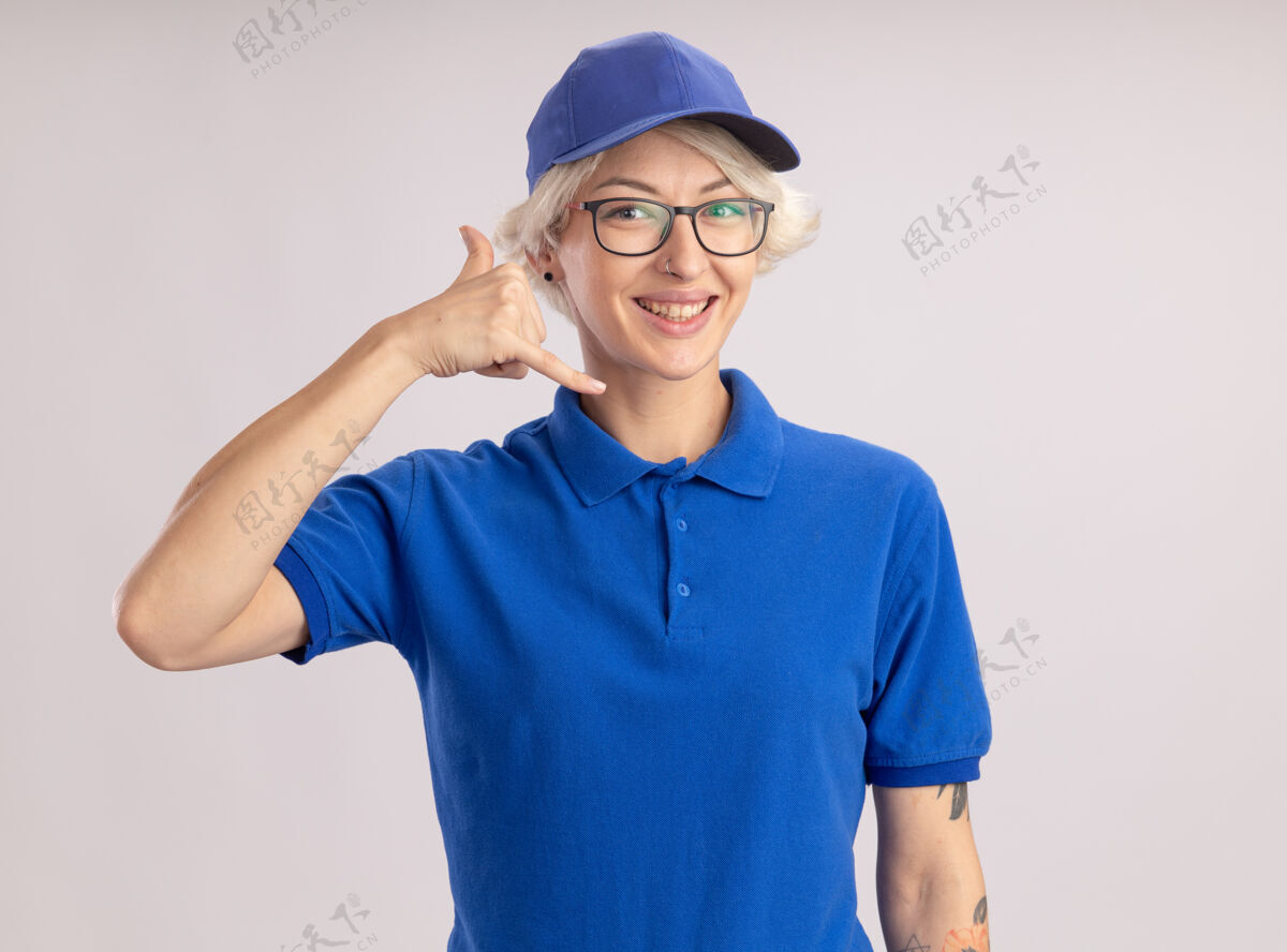 制服身穿蓝色制服 戴着帽子的年轻女送货员站在白墙上做着叫我的手势帽子送货做