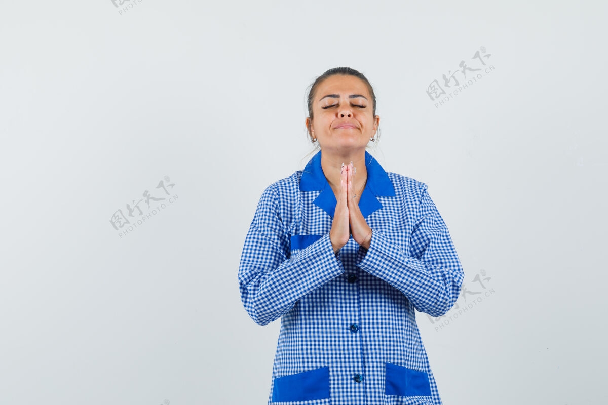 漂亮年轻女子站在祈祷姿势蓝色方格布睡衣衬衫 看起来很放松 前视图姿势皮肤健康