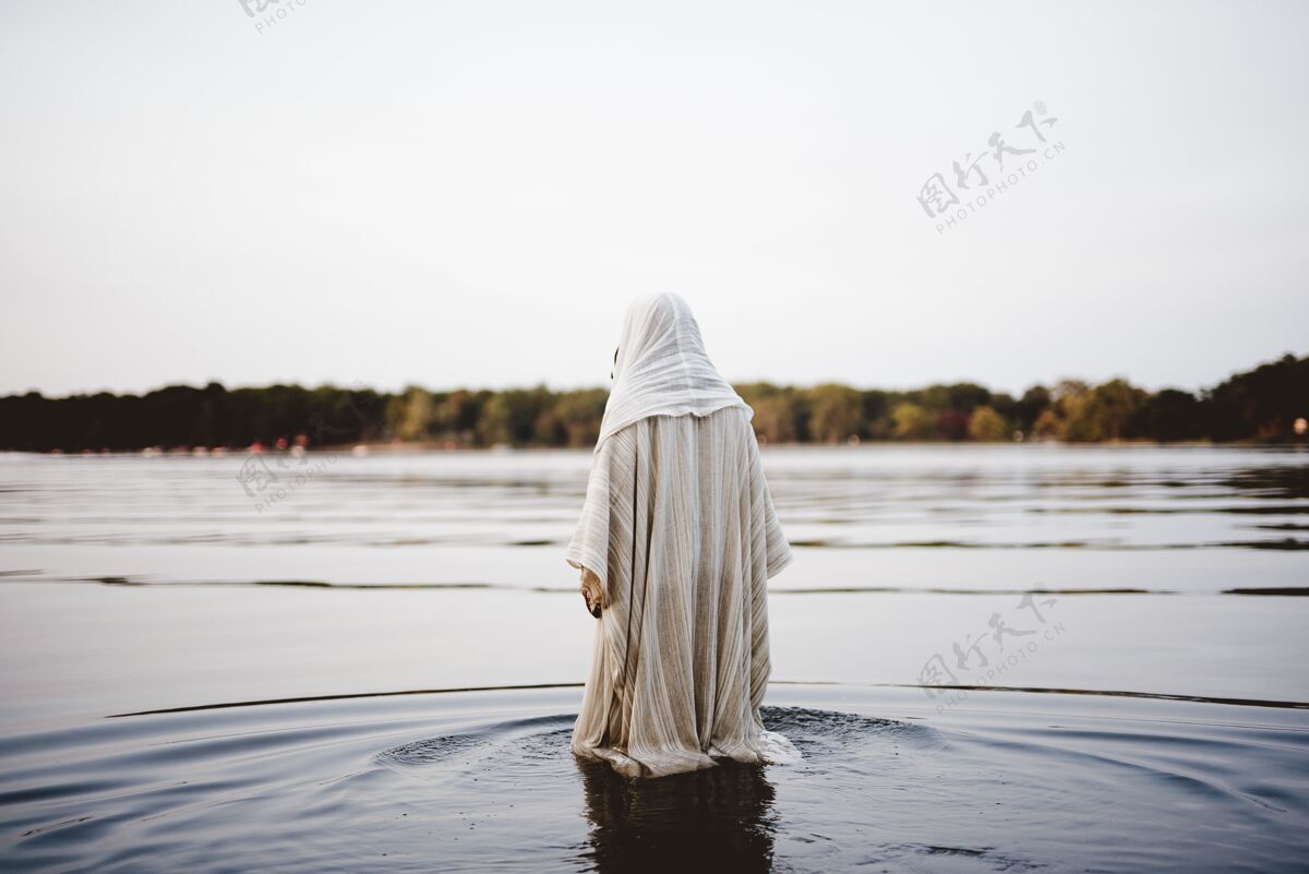 圣穿着圣经长袍在水里行走的人祈祷肖像精神