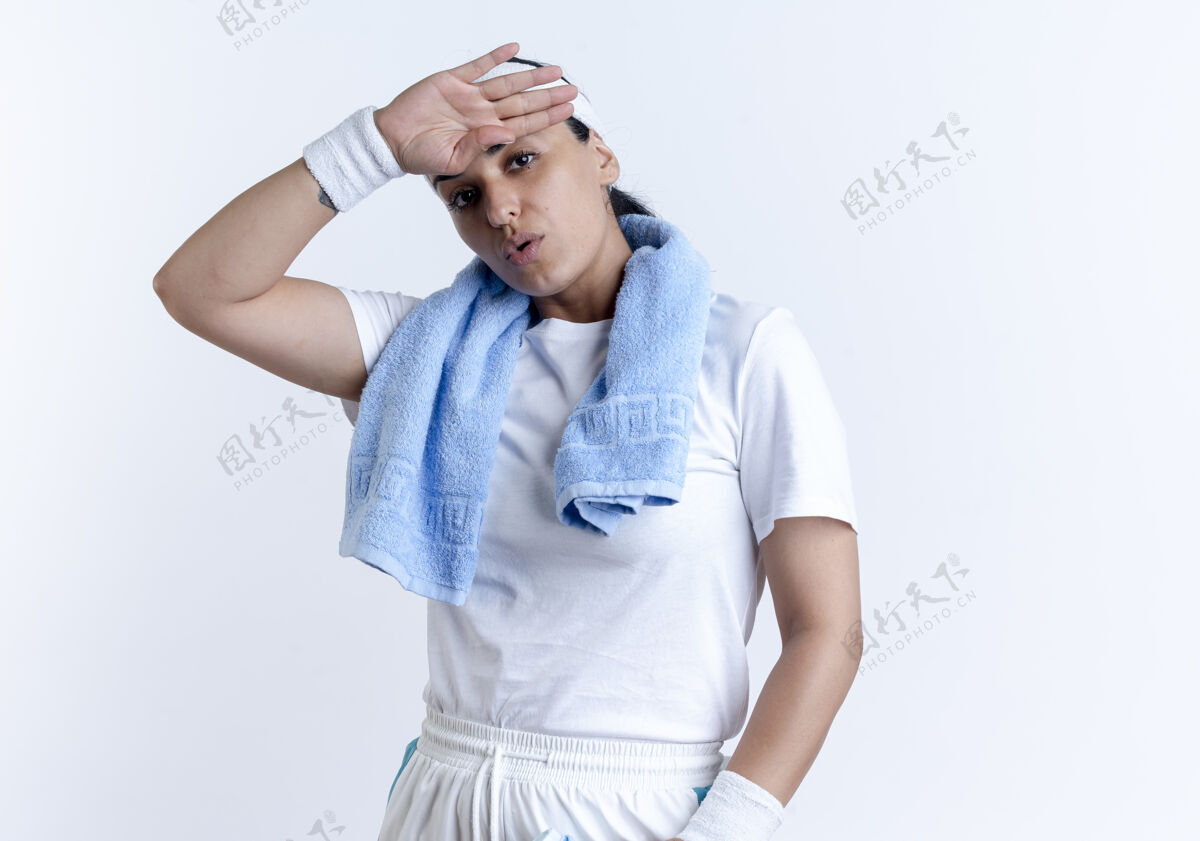 年轻年轻疲惫的白人运动女性戴着头带和手环 脖子上戴着毛巾 手放在额头上 隔离在空白处和复印处放脖子头带