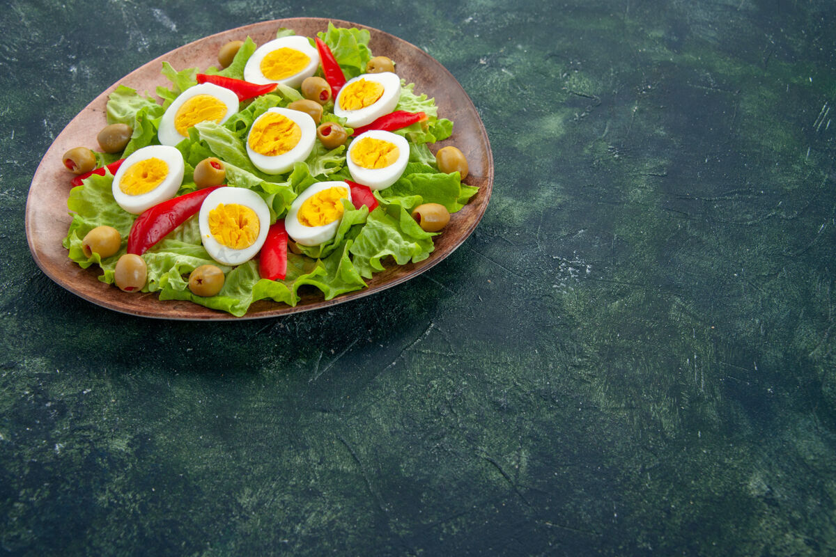 晚餐前视图美味的鸡蛋沙拉与绿色沙拉和橄榄在深蓝色的背景绿色晚餐红辣椒