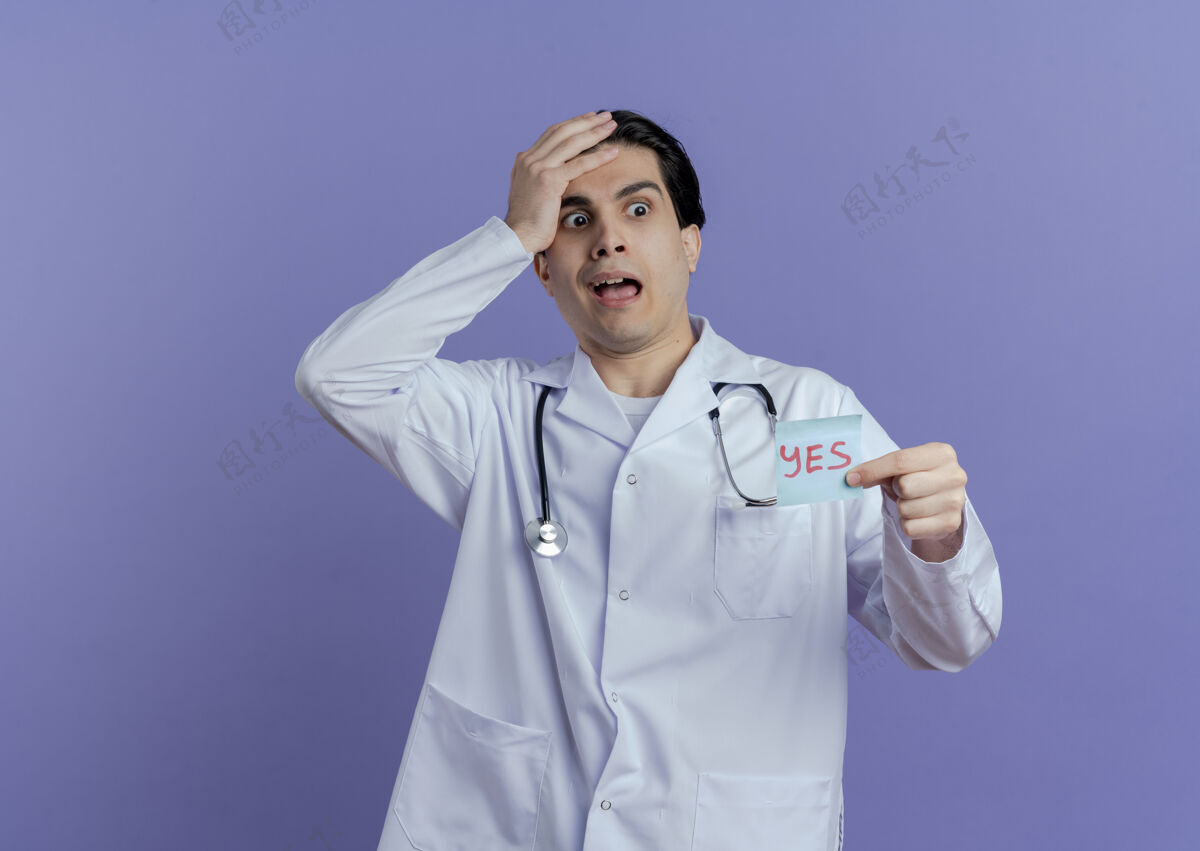 听诊器遗憾的是 年轻的男医生穿着医用长袍 听诊器显示是的 手放在头上 看着隔离在紫色墙上的一边 留着复印空间医生笔记医学