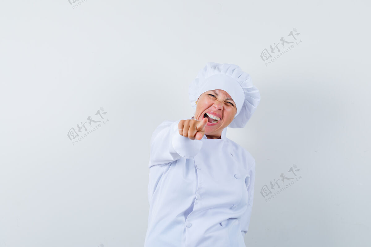 指向一位身穿白色制服的女厨师指着前面 看上去很高兴看女性年轻