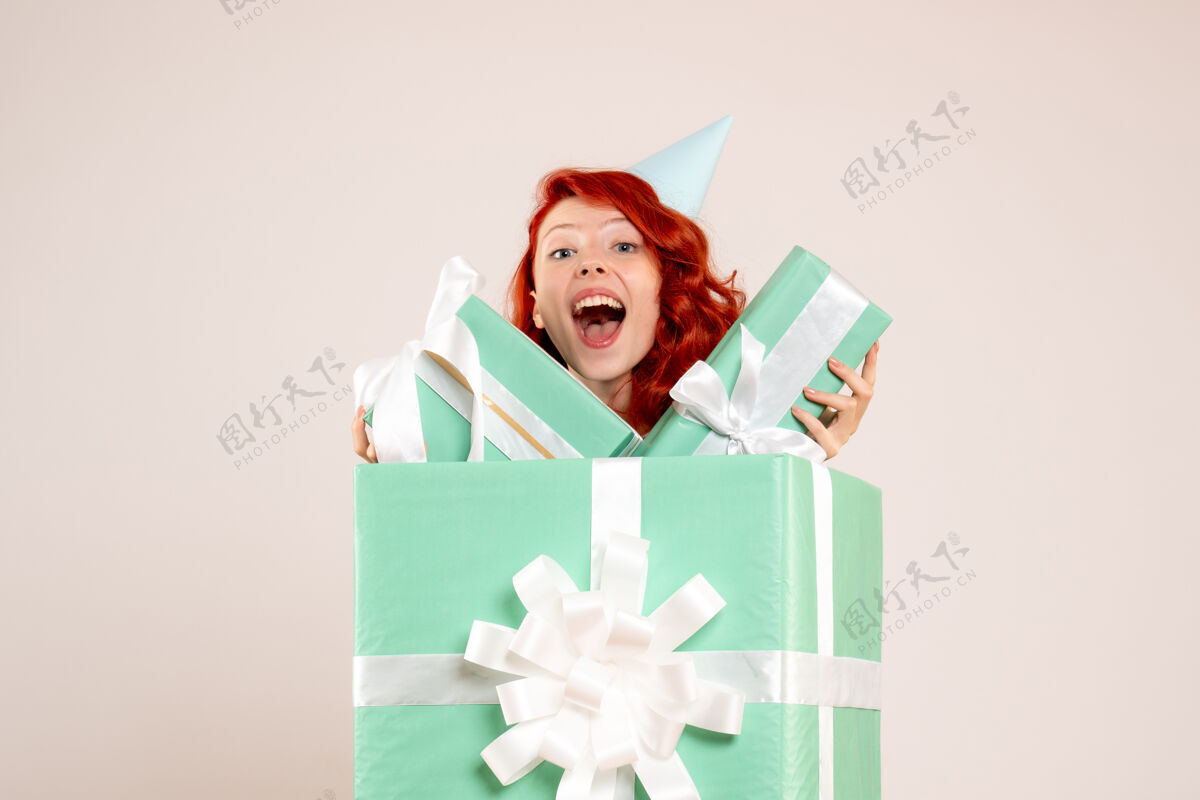 生日正面图：里面的年轻女子拿着其他白色背景的礼物丝带庆祝包装