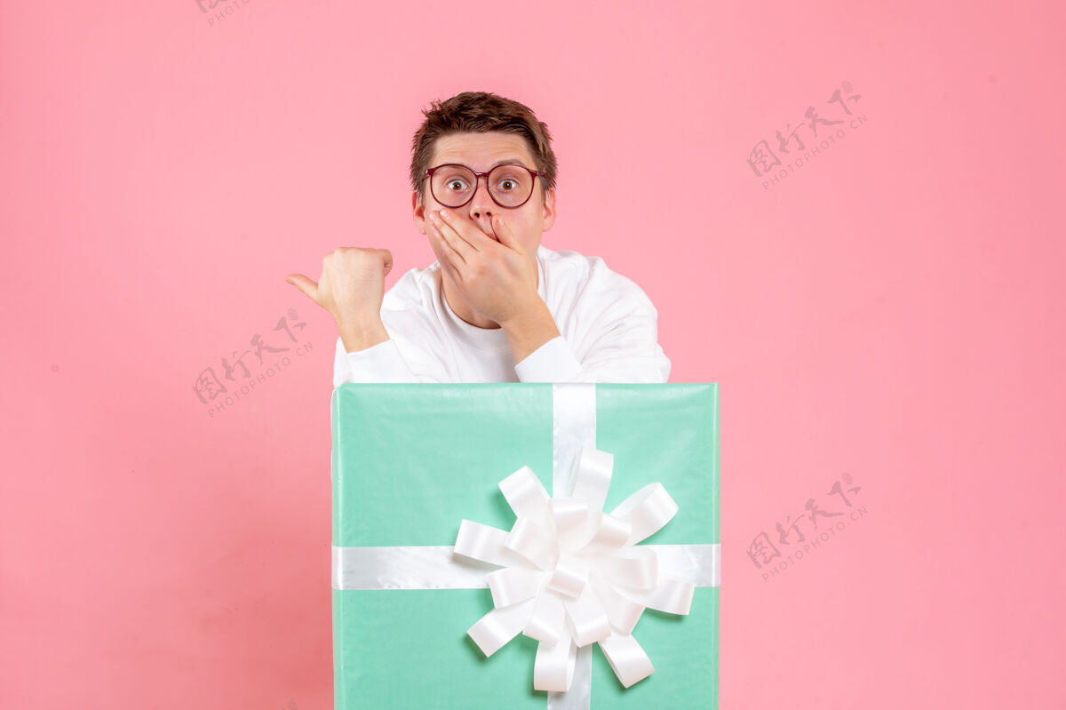 礼物正面图：穿着白色衬衫的年轻男性 粉色背景上有礼物情感白色肖像