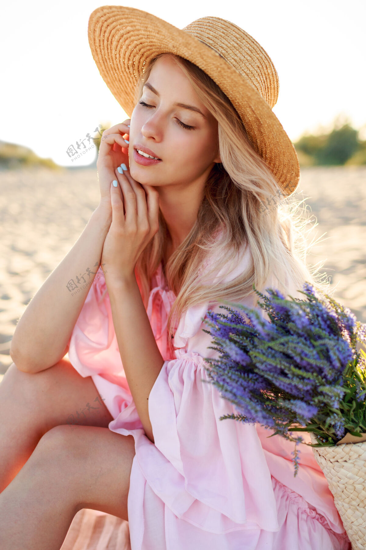 减肥户外生活写真优雅的白人女子坐在阳光明媚的海滩上靠近海洋戴草帽自然背景水果休息沙滩