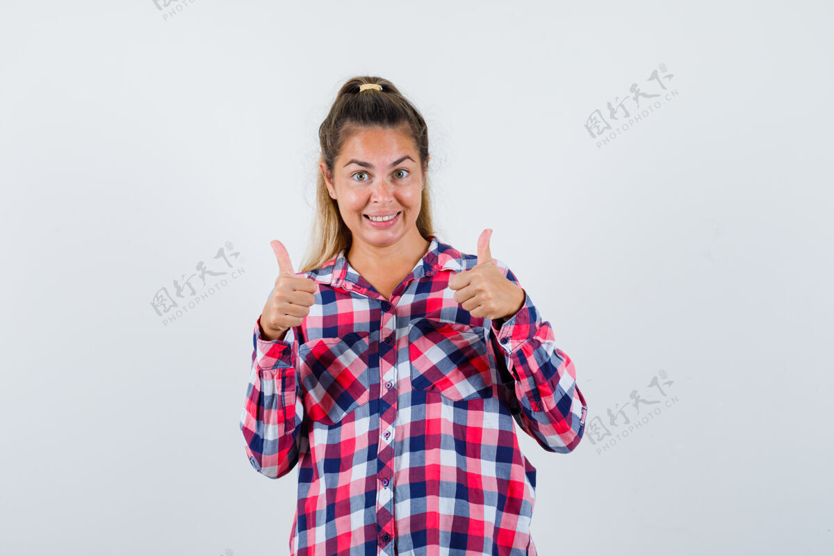 女孩穿着格子衬衫的年轻女士竖起了大拇指 看上去很快乐正视图向上脸衬衫