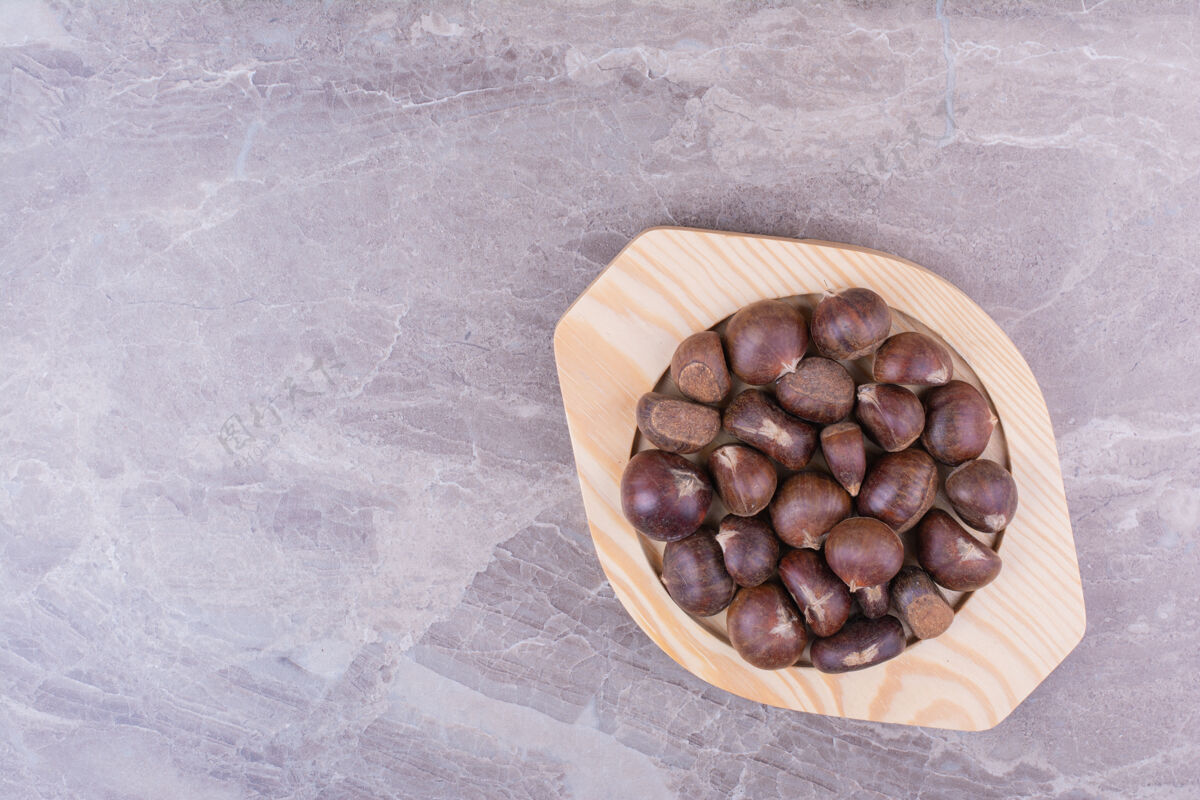 食物把棕色的栗子放在石头上的木盘里季节蔬菜美味
