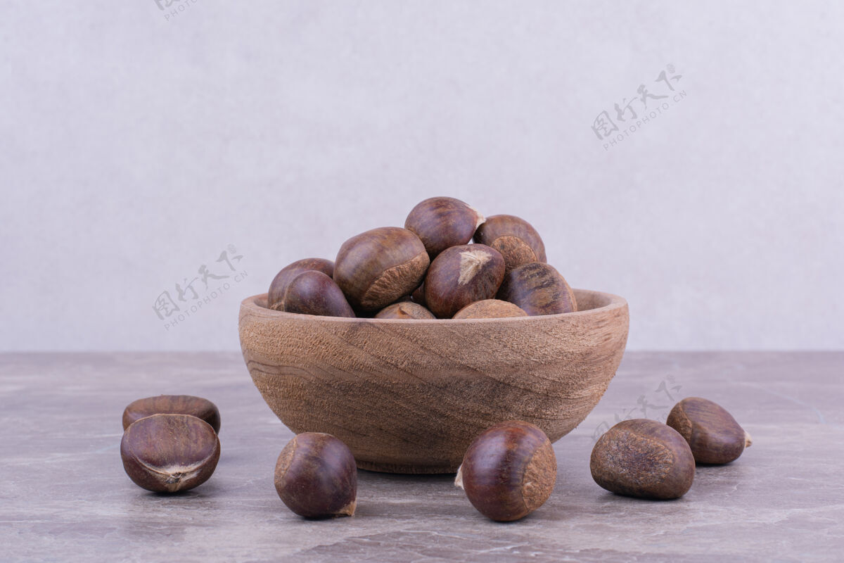 素食棕色的栗子放在一个木杯上的石头上健康生物美味