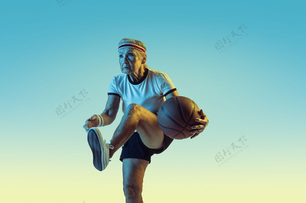健康穿运动服的高级女士在斜坡上打篮球休闲装备准备