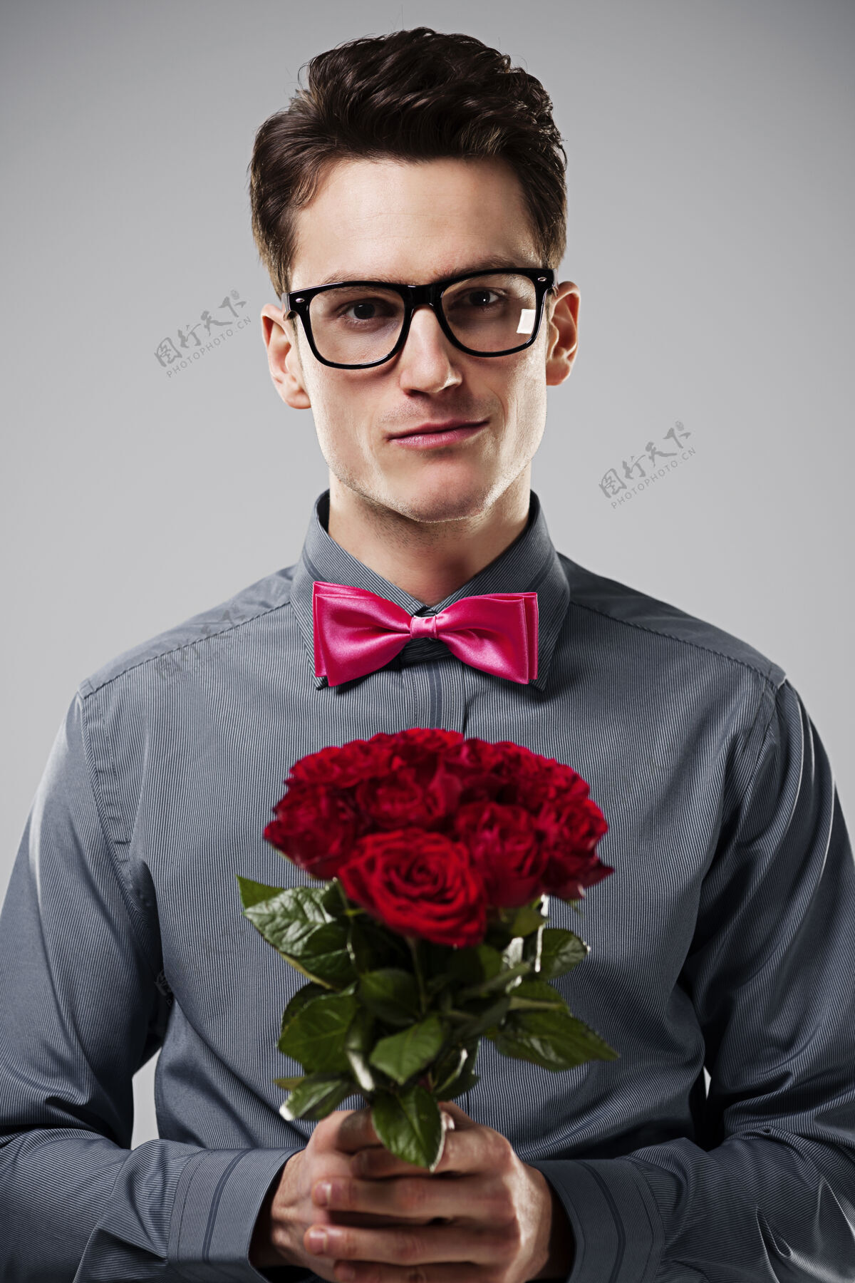 书呆子手持红玫瑰的微笑男人成人举行庆典