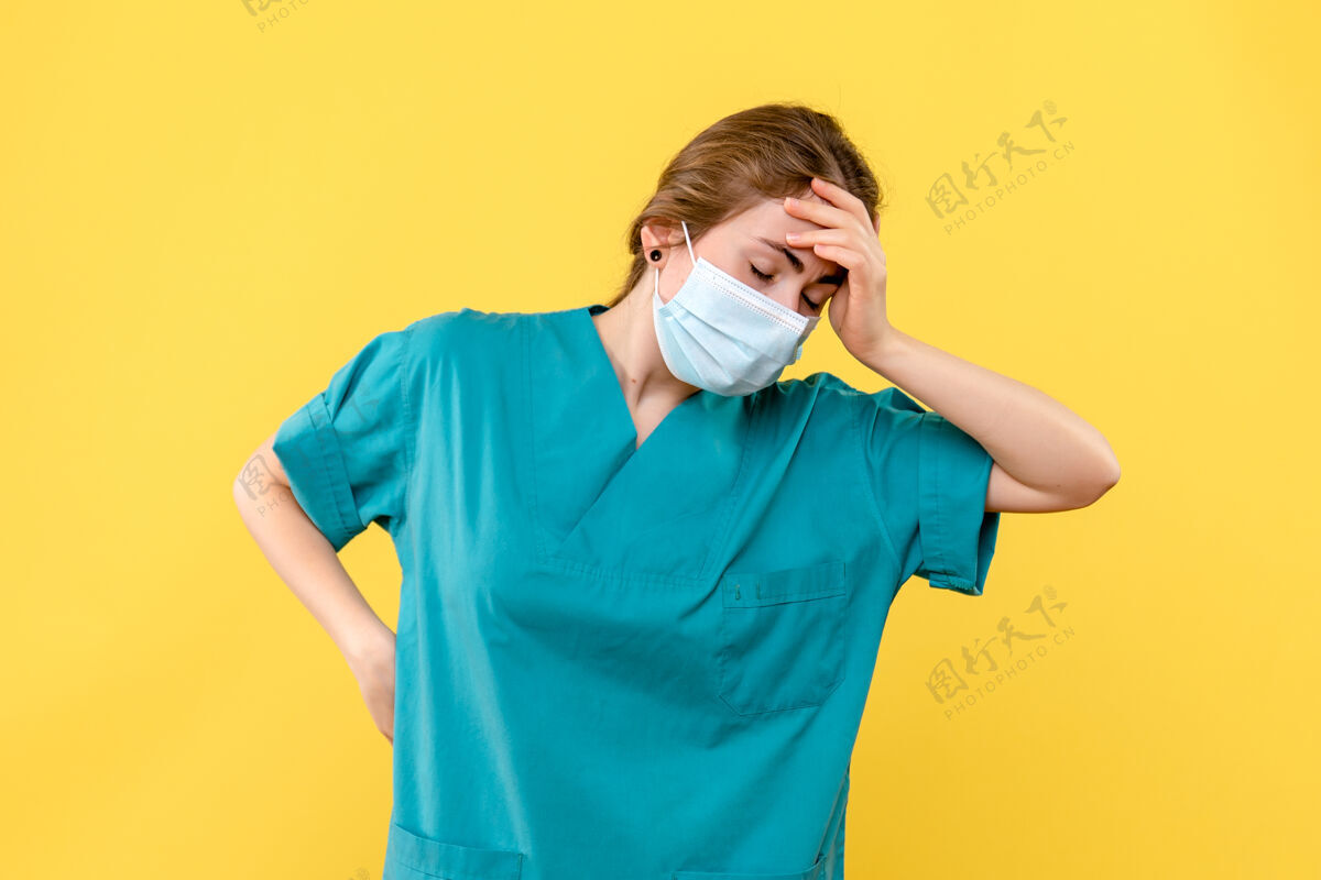 女医生正面图女医生戴着口罩强调黄色背景-卫生院大流行医院成人肖像