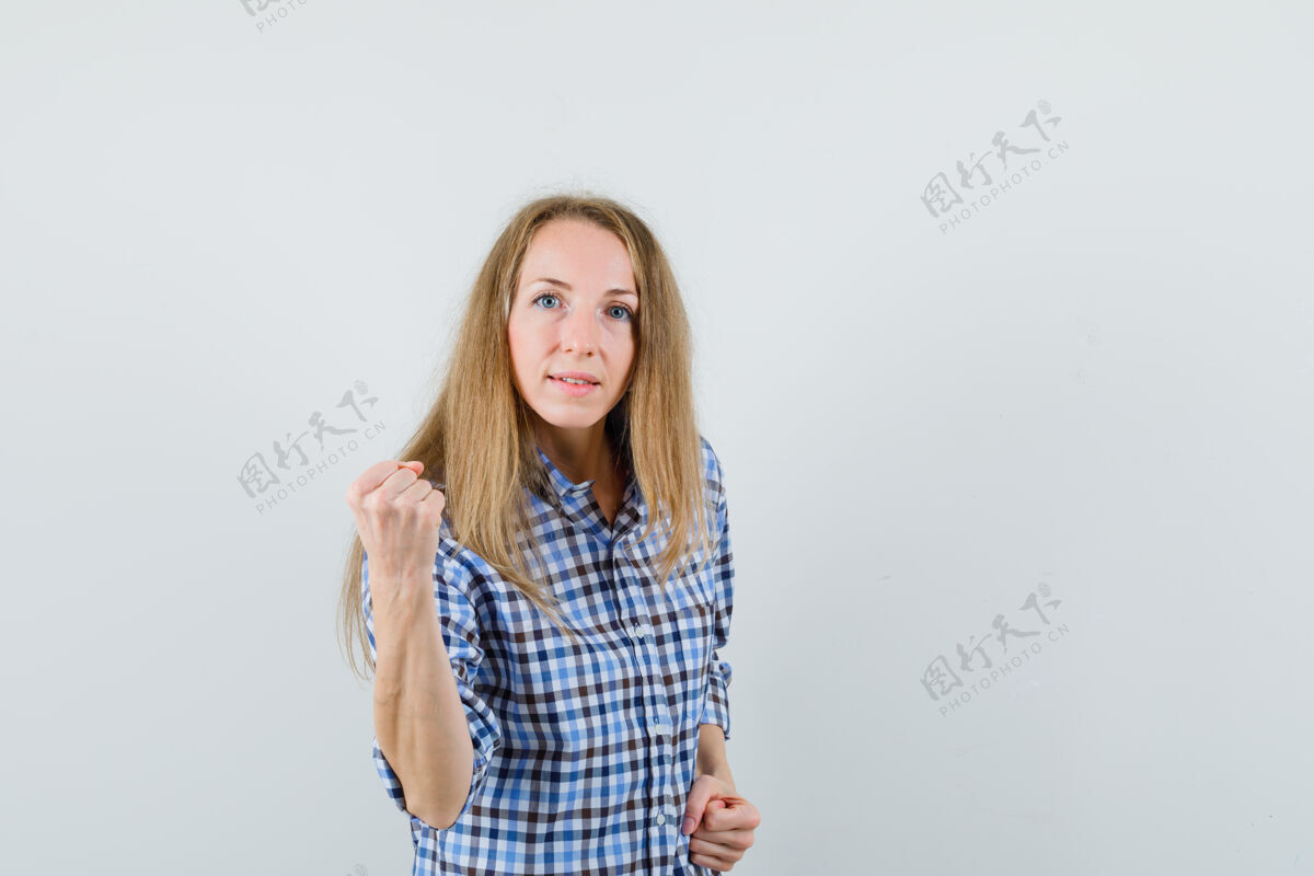 女性金发女郎穿着衬衫举起拳头 看起来很有力量 拳头性感发型