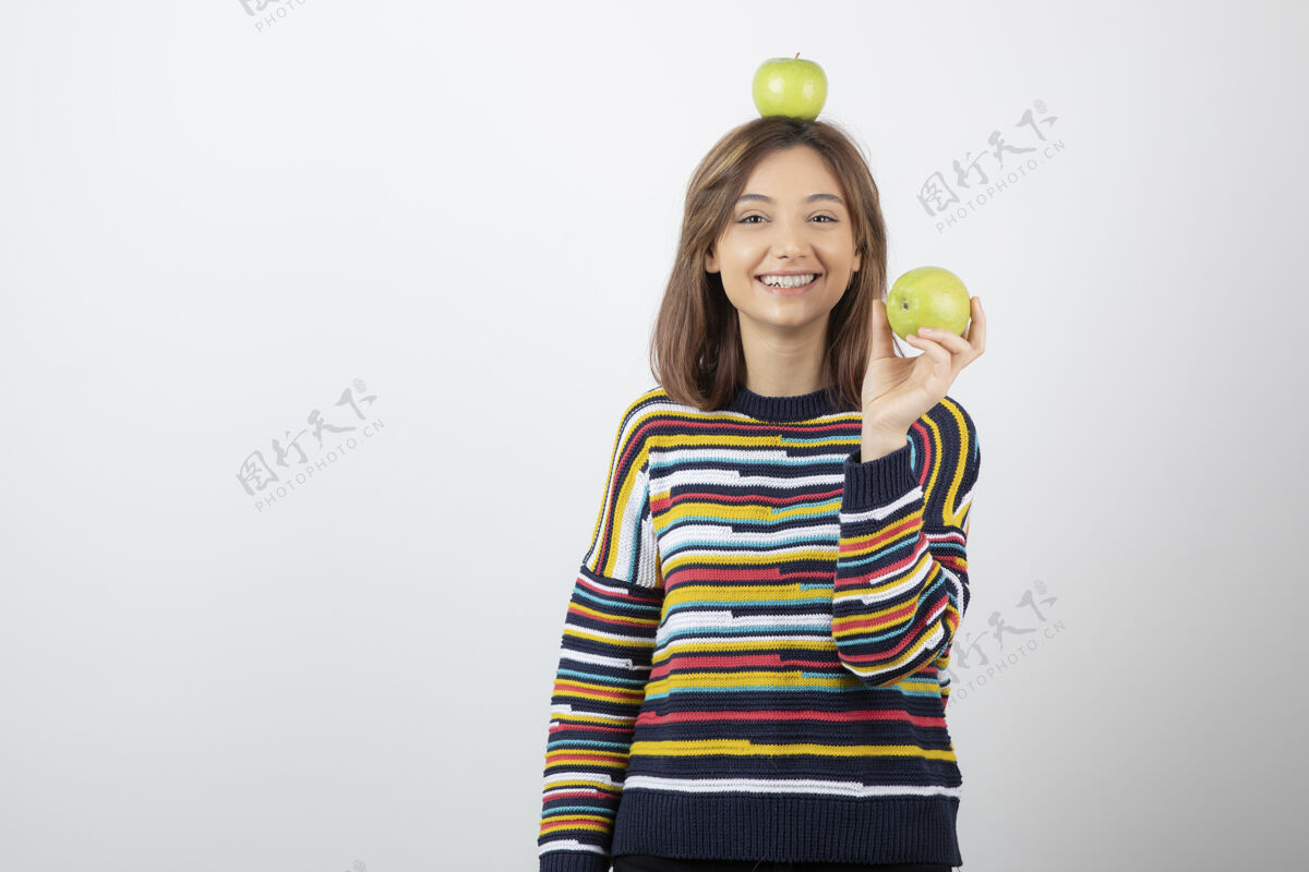 绿色穿着便服的可爱的年轻女子 手拿白底青苹果水果模特拿