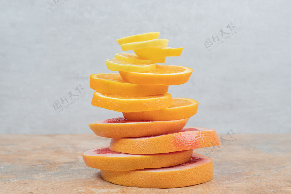 水果一堆柠檬 橘子和葡萄柚片放在大理石桌上高质量的照片成熟新鲜多汁