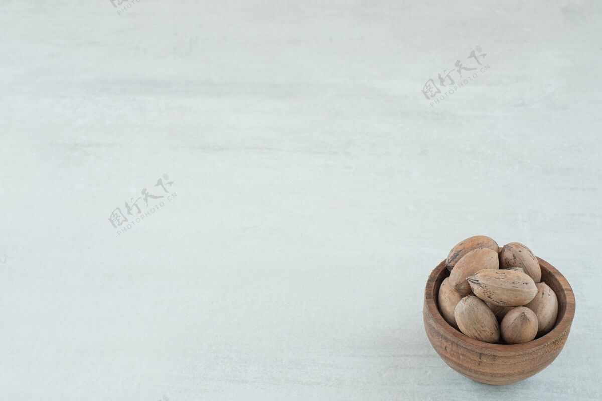 碗白色背景上的一小碗坚果高质量的照片小白色棕色