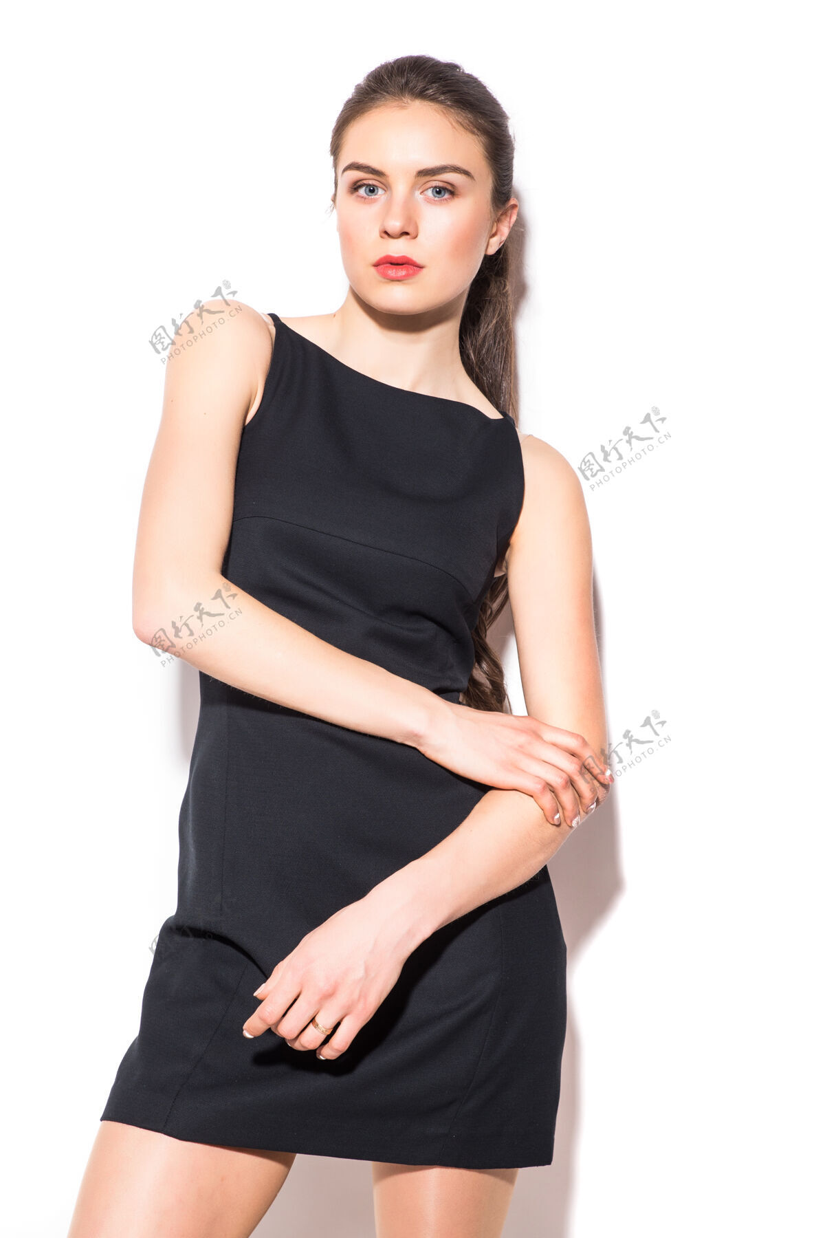 衣服一个穿着黑色裙子的年轻漂亮女人在白色背景上摆姿势的照片垂直吸引女性