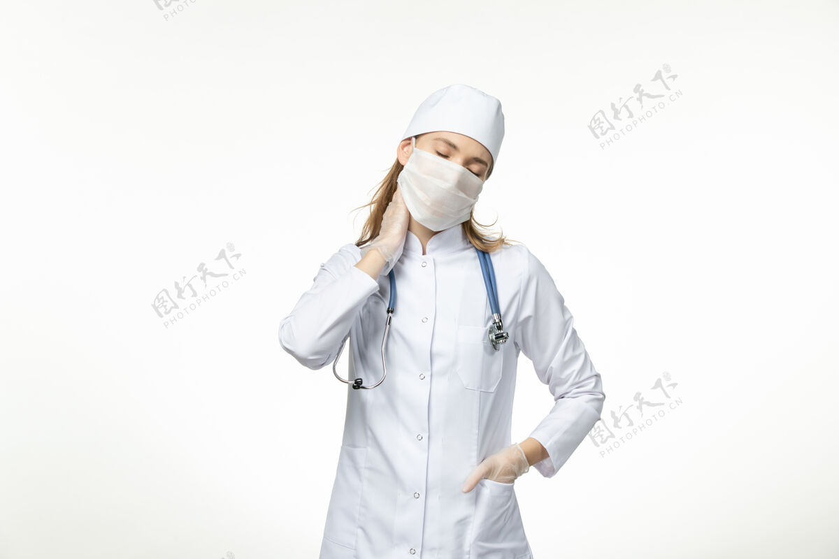 专业正面图女医生穿着医疗服戴着口罩戴着手套 因冠状病毒对轻白壁病大流行冠状病毒人员制服医疗