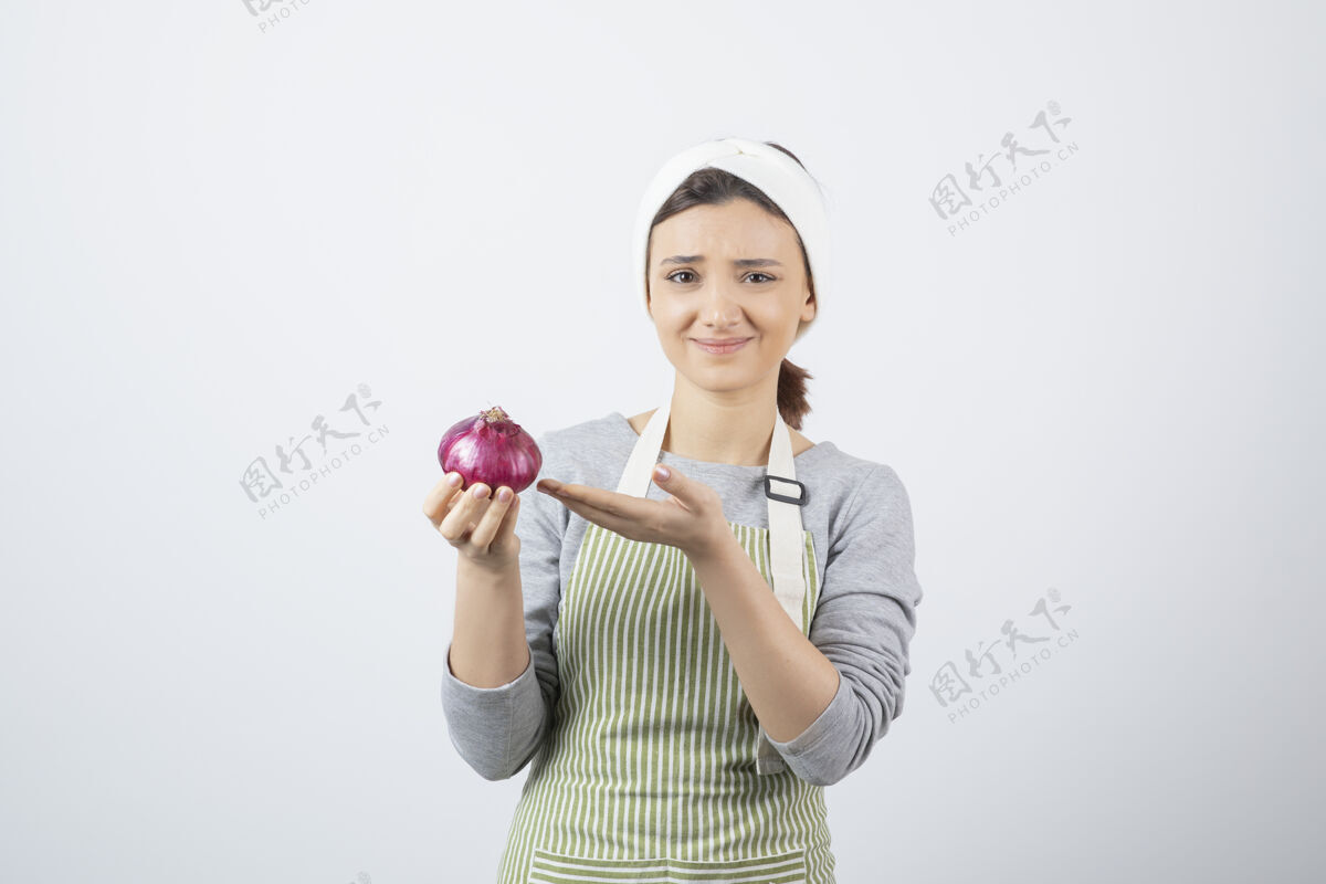 人类穿着围裙拿着紫色洋葱的漂亮女模特紫色围裙蔬菜