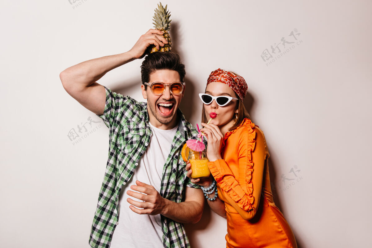 爱情一对乐观的夫妇穿着时尚的夏季服装 正在休息 享受鸡尾酒和菠萝放松男朋友头带