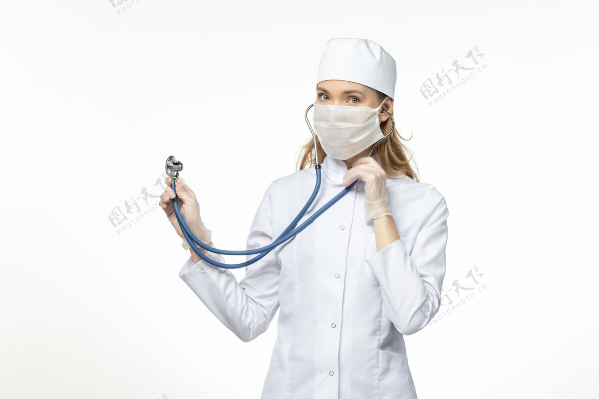 护士正面图女医生穿着白色医疗服 带无菌口罩 因冠状病毒使用听诊器在白色办公桌上患病大流行性疾病冠状病毒-听诊器到期使用