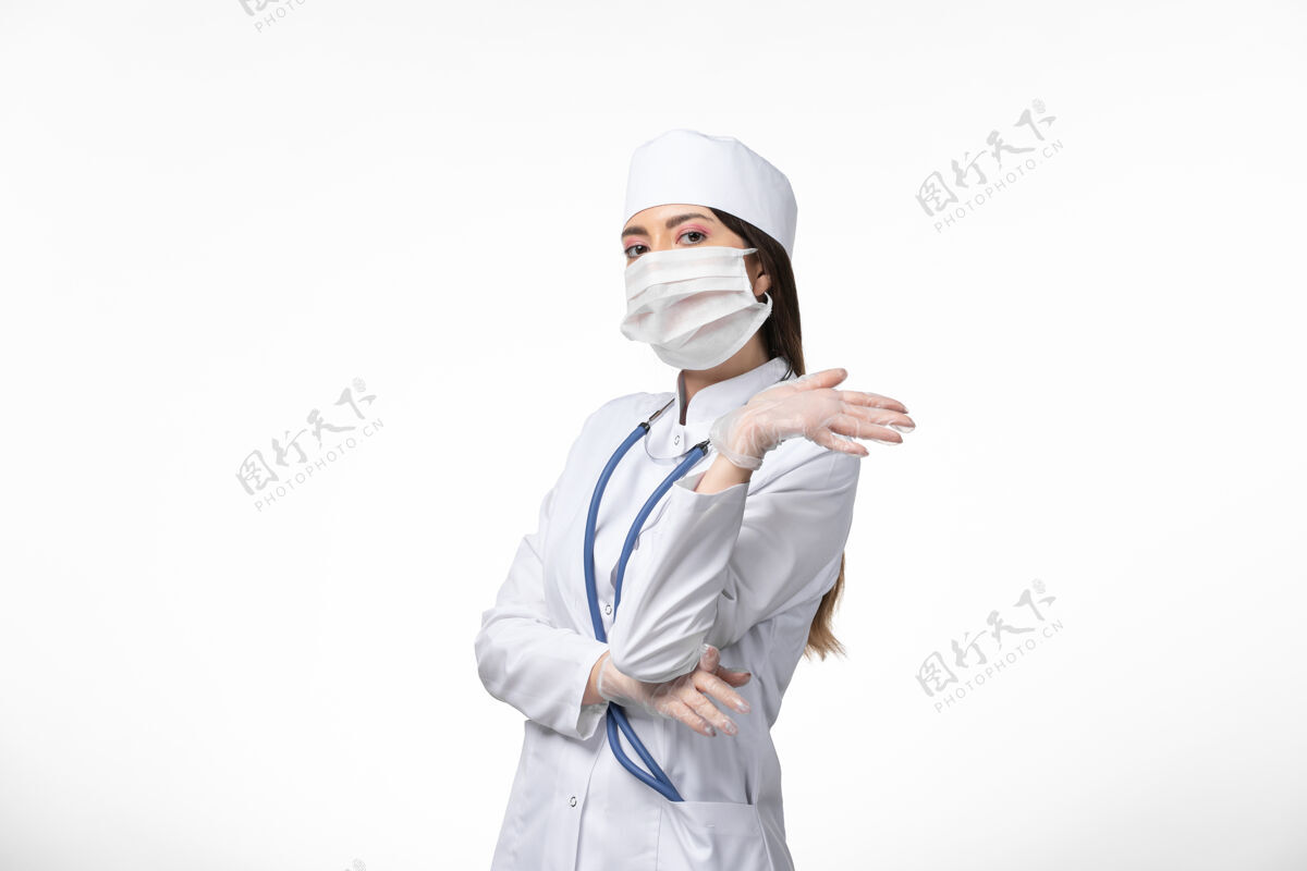 医生正面图女医生穿着白色医疗服 戴着口罩因冠状病毒对白墙健康造成疾病冠状病毒感染观点正面人