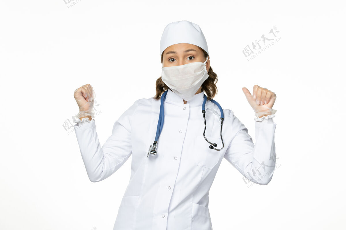 护士正面图女医生穿着白色医疗服 戴着口罩 因白色办公桌上有冠状病毒病隔离冠状病毒医疗制服居家