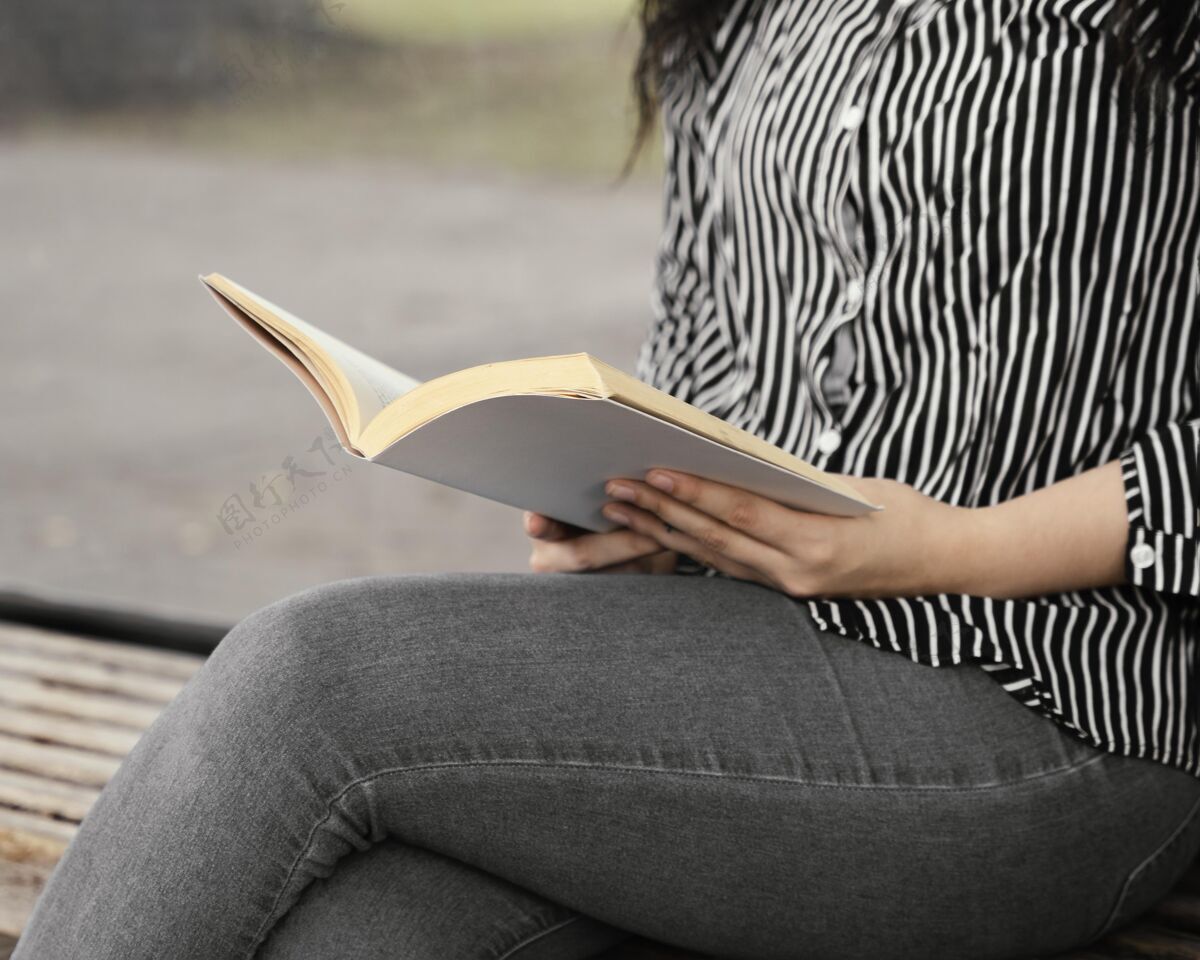 学习年轻女子在户外读一本有趣的书文化教育书