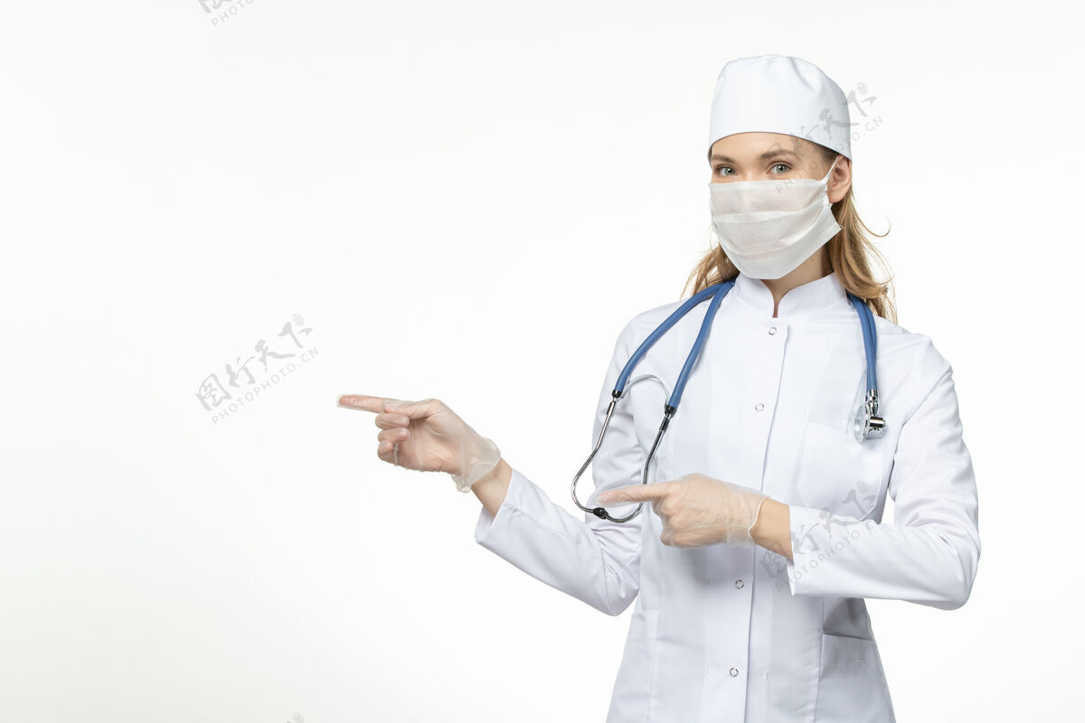 女性前视女医生身穿医疗服戴口罩和手套因冠状病毒上光台病病毒冠状病毒-大流行性疾病医疗器械大流行听诊器