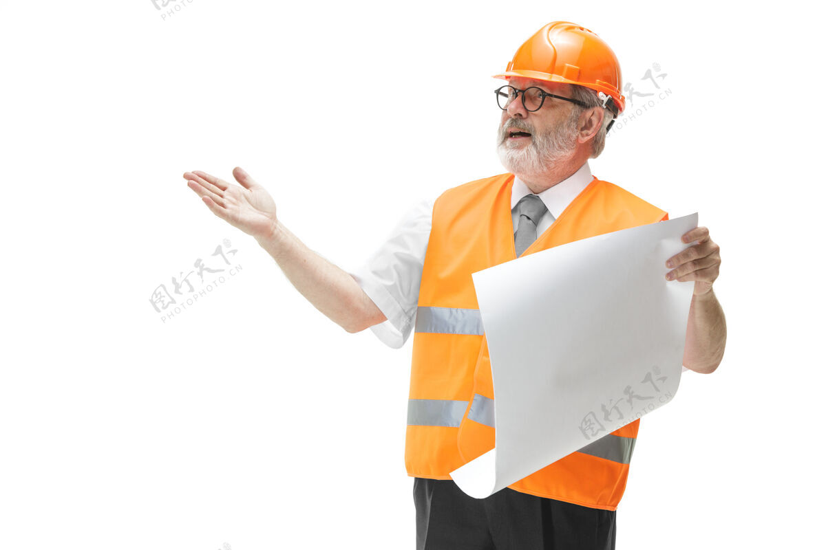头盔穿着建筑背心和橙色头盔的建筑工人站在白色的地面上计划高级工作