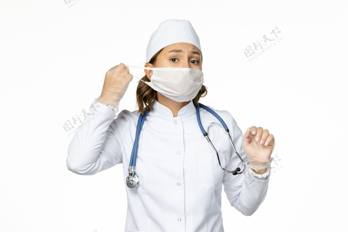 医疗正面图女医生穿着白色医疗服 戴着无菌口罩 在白色墙壁上隔离大流行性疾病药物病毒面罩医生大流行