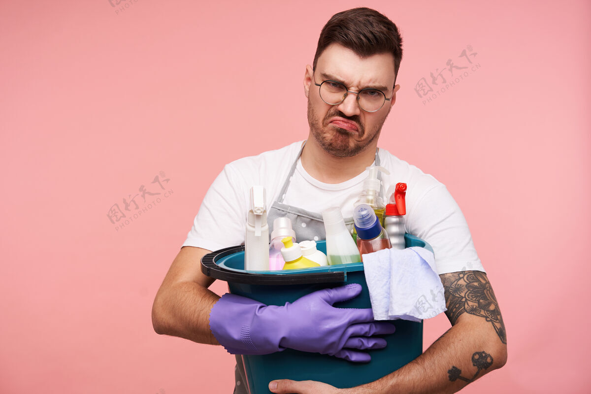 家用心怀不满的年轻短发黑发男性用洗涤剂保存桶洗涤剂休闲男士