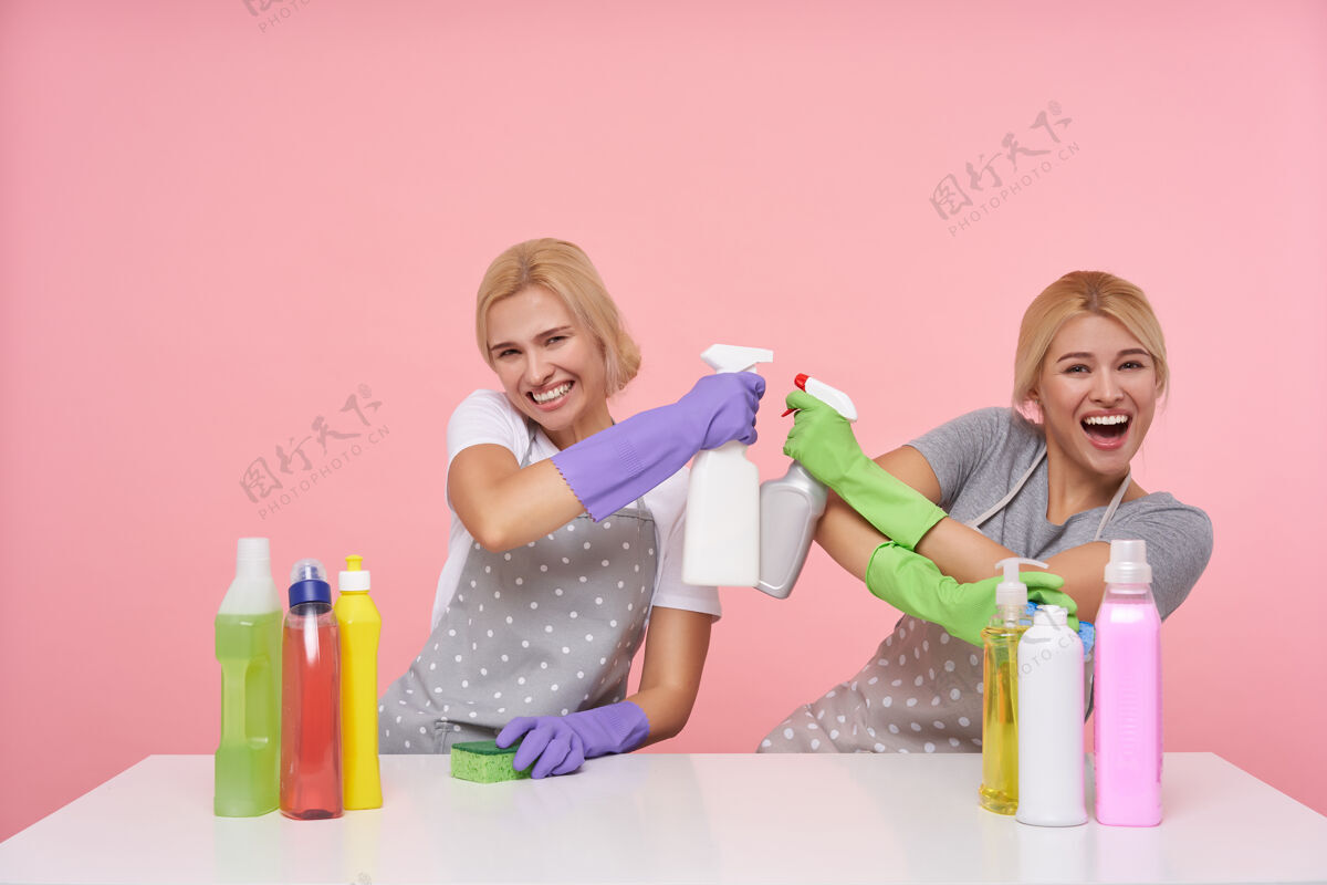 头发年轻的金发可爱的主妇们戴着橡胶手套准备春季大扫除妹妹波尔卡洗涤剂